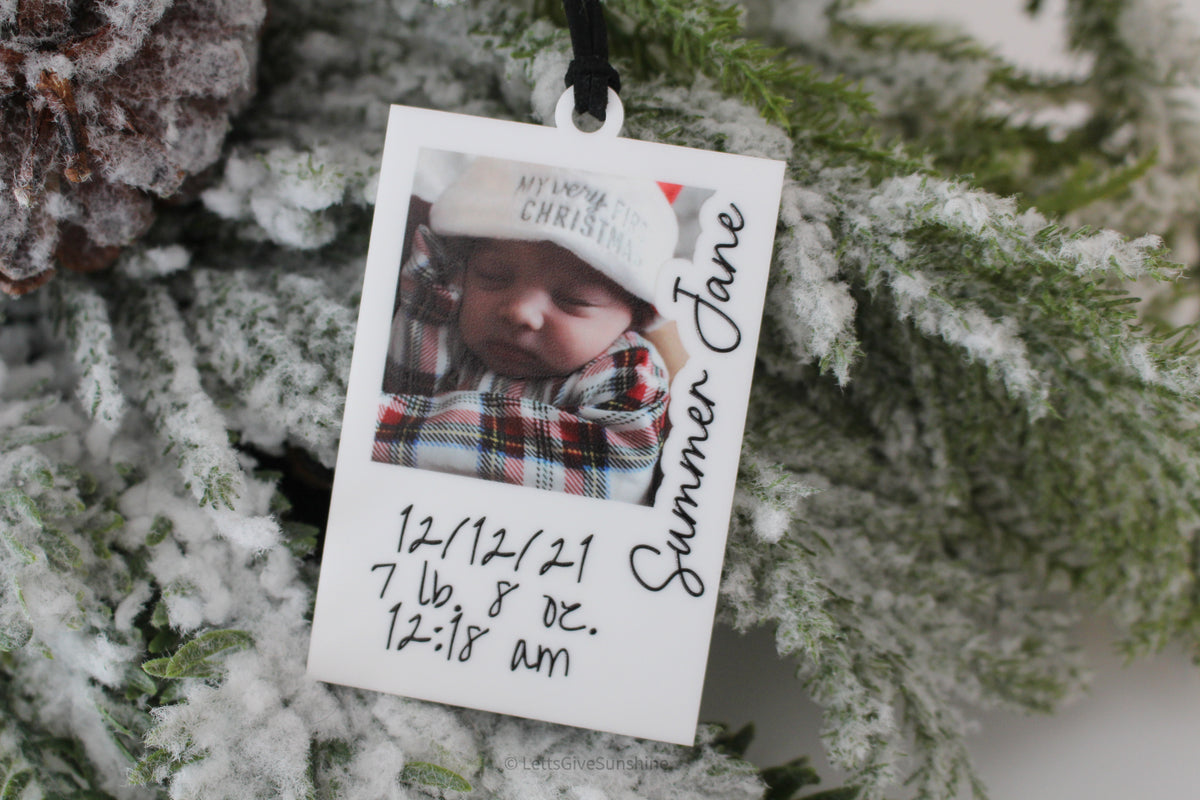 Personalized baby photo ornament featuring a newborn Christmas picture, baby name, and birth details on white acrylic, perfect for a Baby’s First Christmas keepsake.