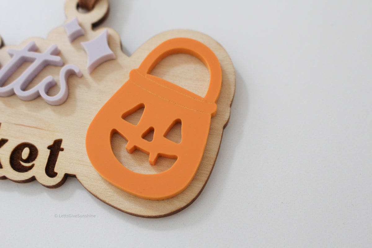 Close-up of orange jack-o’-lantern bucket detail on a personalized wooden Halloween Boo Basket tag