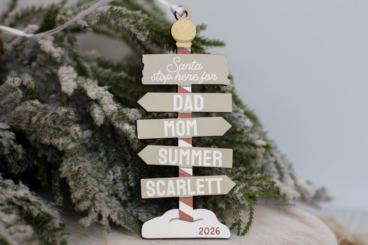 Custom wooden family Christmas ornament in neutral colours, featuring personalized name signs, Santa Stop Here design, and 2026 keepsake detail