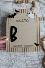 Personalized wooden Baby's First Halloween footprint board with striped arch border, black bats, white ghost and blank space for baby's painted footprints.