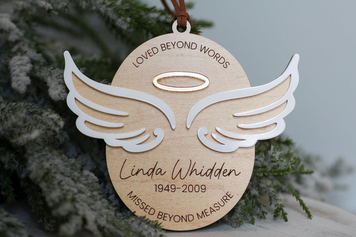 Personalized memorial Christmas ornament with angel wings, halo, Linda Whidden name, years 1949 to 2009, and loved beyond words missed beyond measure message.