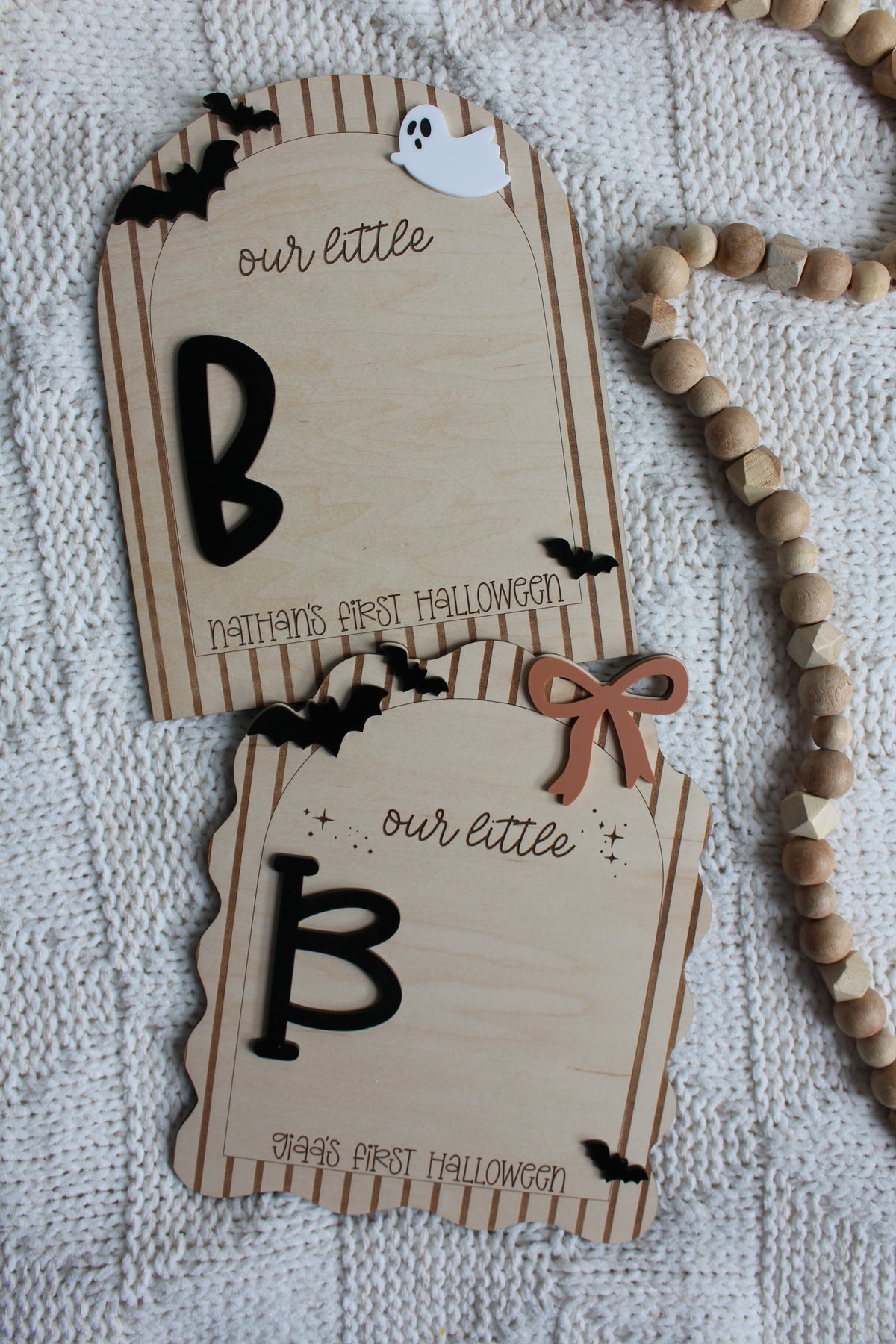 Personalized wooden Baby's First Halloween footprint board with striped arch border, black bats, white ghost and blank space for baby's painted footprints.