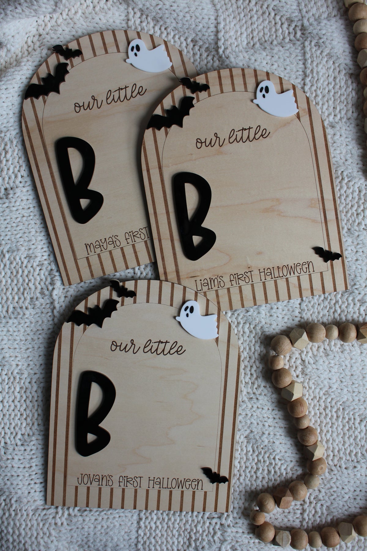 Personalized wooden Baby's First Halloween footprint board with striped arch border, black bats, white ghost and blank space for baby's painted footprints.