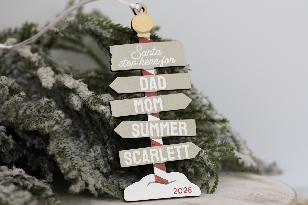 Custom wooden family Christmas ornament in neutral colours, featuring personalized name signs, Santa Stop Here design, and 2026 keepsake detail