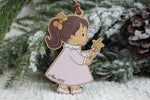 Personalized wooden Christmas ornament featuring a little girl in a pink dress holding a gold star wand, customized with the name Alice and year 2026