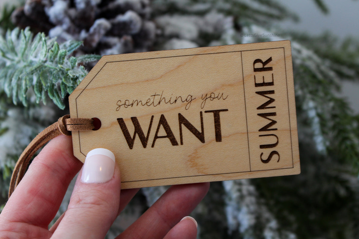 Personalized Something You Want wooden Christmas gift tag engraved with Summer, featuring a natural wood finish and brown faux suede cord.