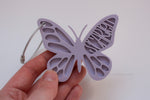 Personalized lavender butterfly-shaped acrylic bag tag with the name Scarlett and a silver cable loop.