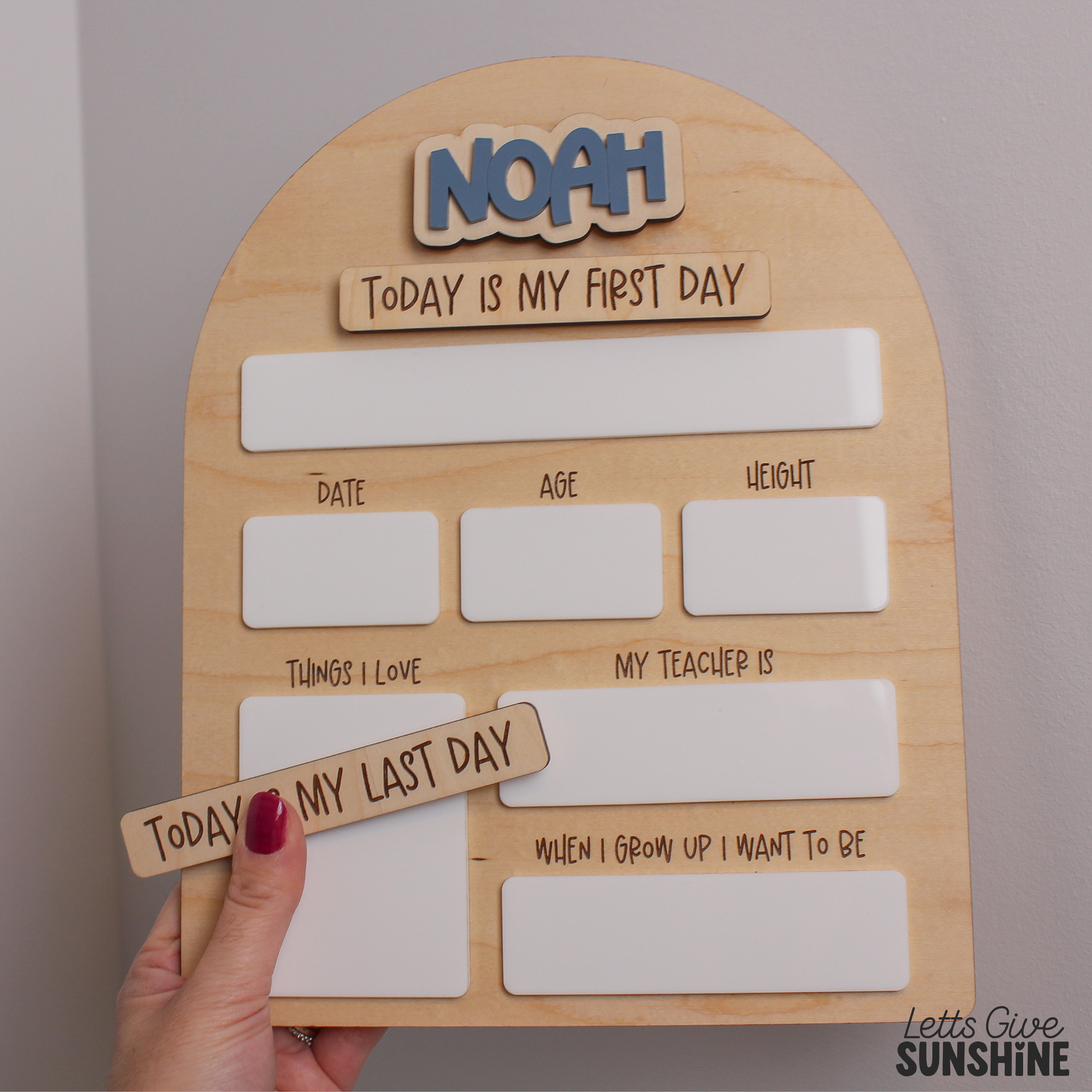 Personalized wooden first day of school dry erase milestone board with blue raised acrylic name Noah, reusable writing sections, and interchangeable “Today Is My First Day” and “Today Is My Last Day” pieces.

