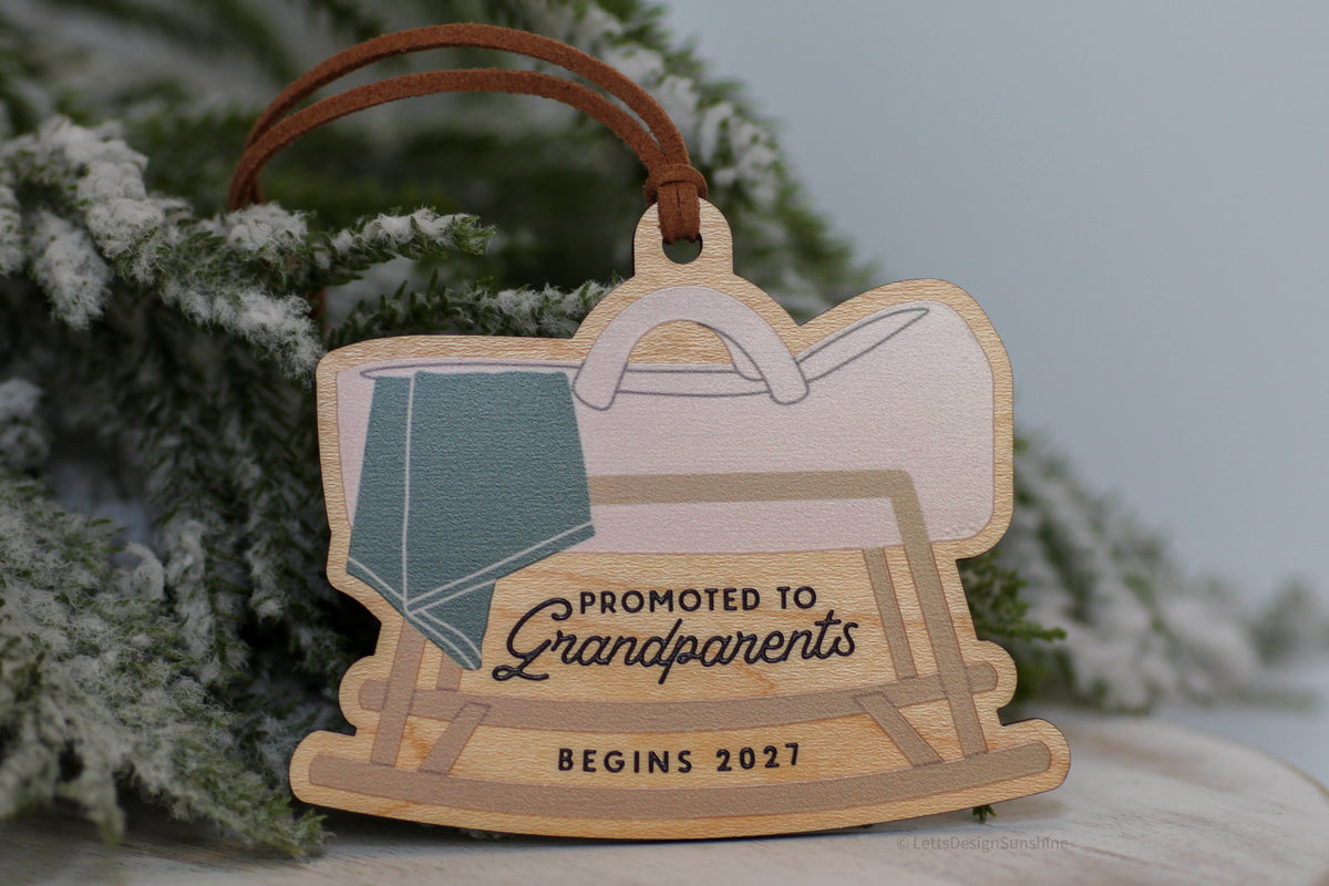 Pregnancy reveal Christmas ornament for grandparents-to-be with a pastel baby bassinet illustration, Promoted to Grandparents message and personalized 2027 year.