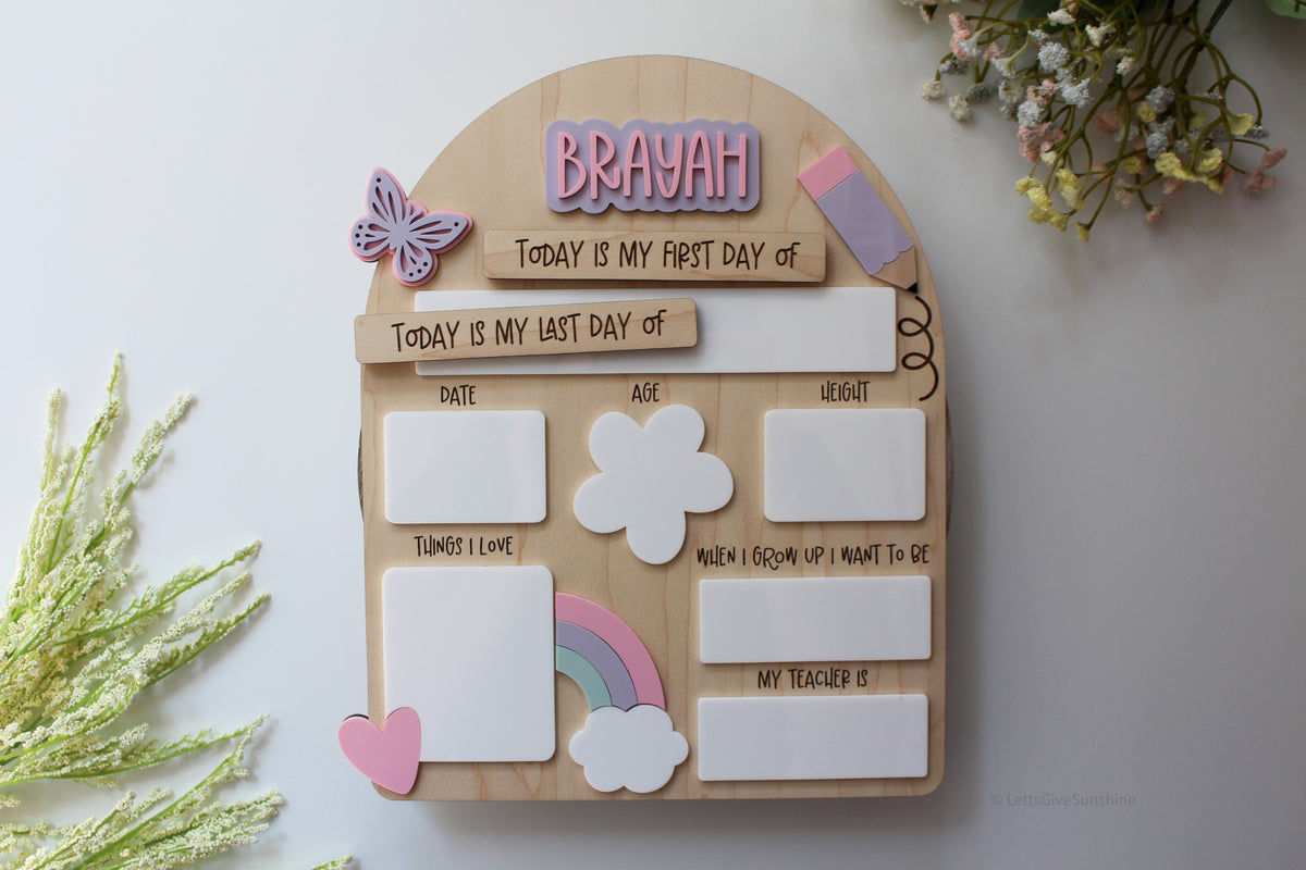 Personalized wooden first and last day of school board with the name Brayah, pastel rainbow, butterfly, hearts, and reusable dry-erase spaces for grade, date, age, height, favourite things, future dream, and teacher