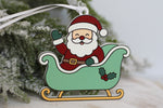 Santa Tracker Christmas ornament featuring Santa waving from a green Christmas sleigh, made from acrylic with a white hanging ribbon.
