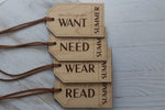 Set of four wooden Christmas gift tags engraved with Something You Want, Need, Wear and Read, personalized with Summer and finished with brown cords.