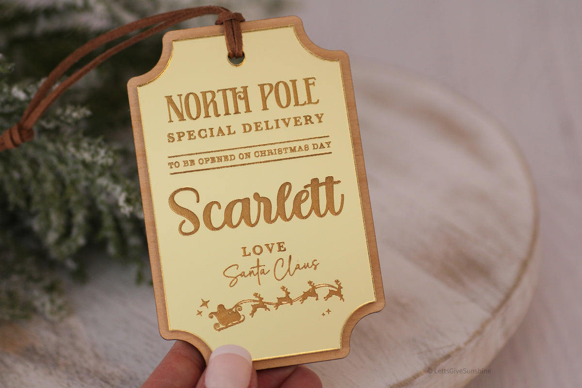 Custom Santa gift tag made from layered wood and gold mirror acrylic, personalized with Scarlett and engraved with To Be Opened on Christmas Day.