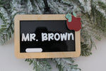 Personalized classroom chalkboard Christmas ornament for teachers featuring a natural wood frame, custom white name lettering and black hanging cord