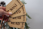 Reusable personalized Christmas gift tags made from natural wood, showing Want, Need, Wear and Read categories for children's holiday presents.