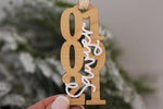 Custom wooden wedding date ornament with white acrylic family name lettering and gold hanging ribbon, a personalized Christmas gift for newly married couples.
