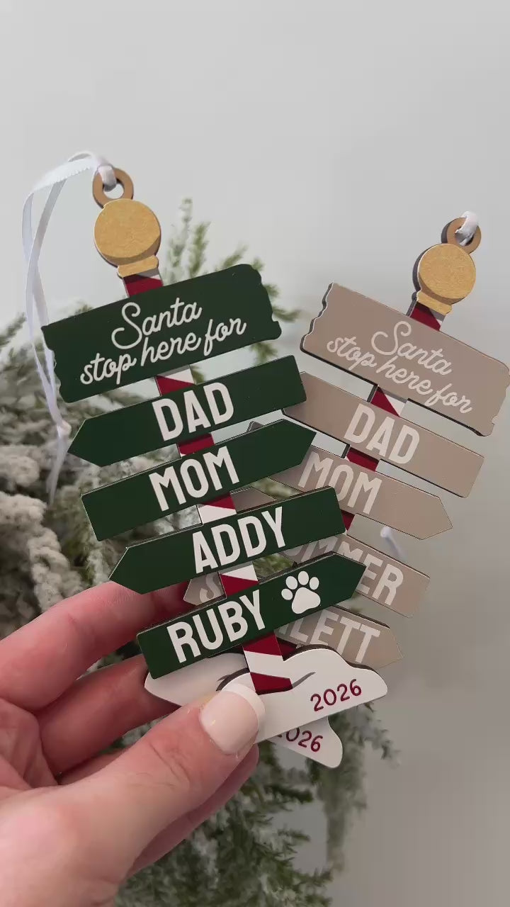 Personalized family Christmas ornament 2026 featuring green and neutral colour options, custom family name signs, optional pet paw prints, and Santa Stop Here wooden design